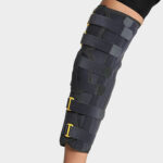 Attelle de genou Zimmer, longueur 45cm, en plastique rigide, avec des sangles réglables en velcro. L'attelle est blanche et conçue pour offrir soutien et stabilité au genou.