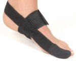 Attelle Hallux Valgus Morsa Cyberg, vue de dessus, en plastique blanc et noir, conçue pour le gros orteil. Elle comprend une tige réglable, des sangles velcro et une forme ergonomique destinée à corriger la position de l'oignon.