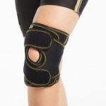 Genouillère Morsa Cyberg, vue de face, de couleur noire, conçue pour le genou. Elle présente un renfort rigide autour de la rotule et des sangles réglables pour un maintien personnalisé. L'image met en évidence la structure ferme de la genouillère et son aspect respirant.