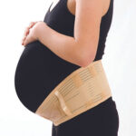 Corset lombo-sacré Morsa Cyberg pour femme enceinte, visiblement confortable. Ce soutien-gorge de grossesse de couleur neutre enveloppe le ventre et le bas du dos pour un maintien optimal et une meilleure posture. Disponible dans différentes tailles.