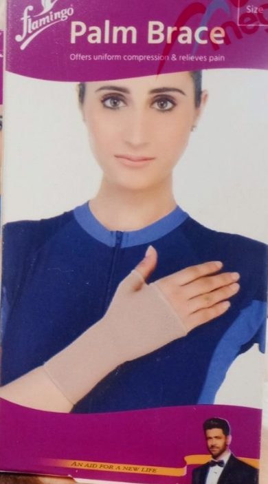 Bandage de poignet rose flamingo, modèle OC 2104, conçu pour le soutien et la protection en cas d'entorse, tendinite ou douleur. Le bandage est respirant et disponible en différentes tailles.