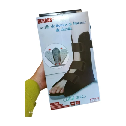 Attelle de cheville Berbas BR328, modèle M/L, conçue pour le soutien et la récupération après fractures ou entorses. L'attelle, présentée sur un fond neutre, est de couleur grise avec des sangles réglables en velcro pour un ajustement personnalisé. Elle possède un système de stabilisation visible au niveau de la cheville.