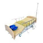 Lit médicalisé manuel multipositions avec garde-robe intégré et matelas anti-escarres. Le lit est visiblement réglable, suggérant des positions variées. Il semble conçu pour le confort et le soutien, potentiellement destiné aux personnes à mobilité réduite, comme l'indique sa conception accessible.