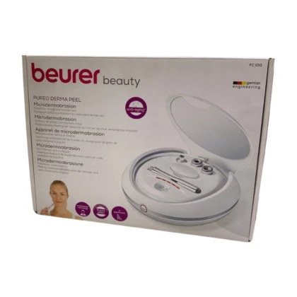 Beurer FC 100, appareil de microdermabrasion blanc et noir, présenté sur un fond neutre. L'appareil est compact, avec une poignée ergonomique et un réservoir visible. Des embouts d'exfoliation sont également visibles.